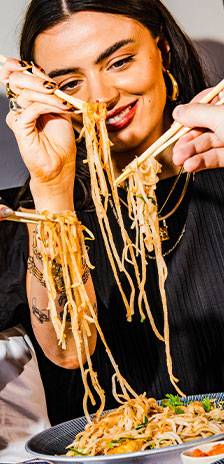 woman smiling eating noodles